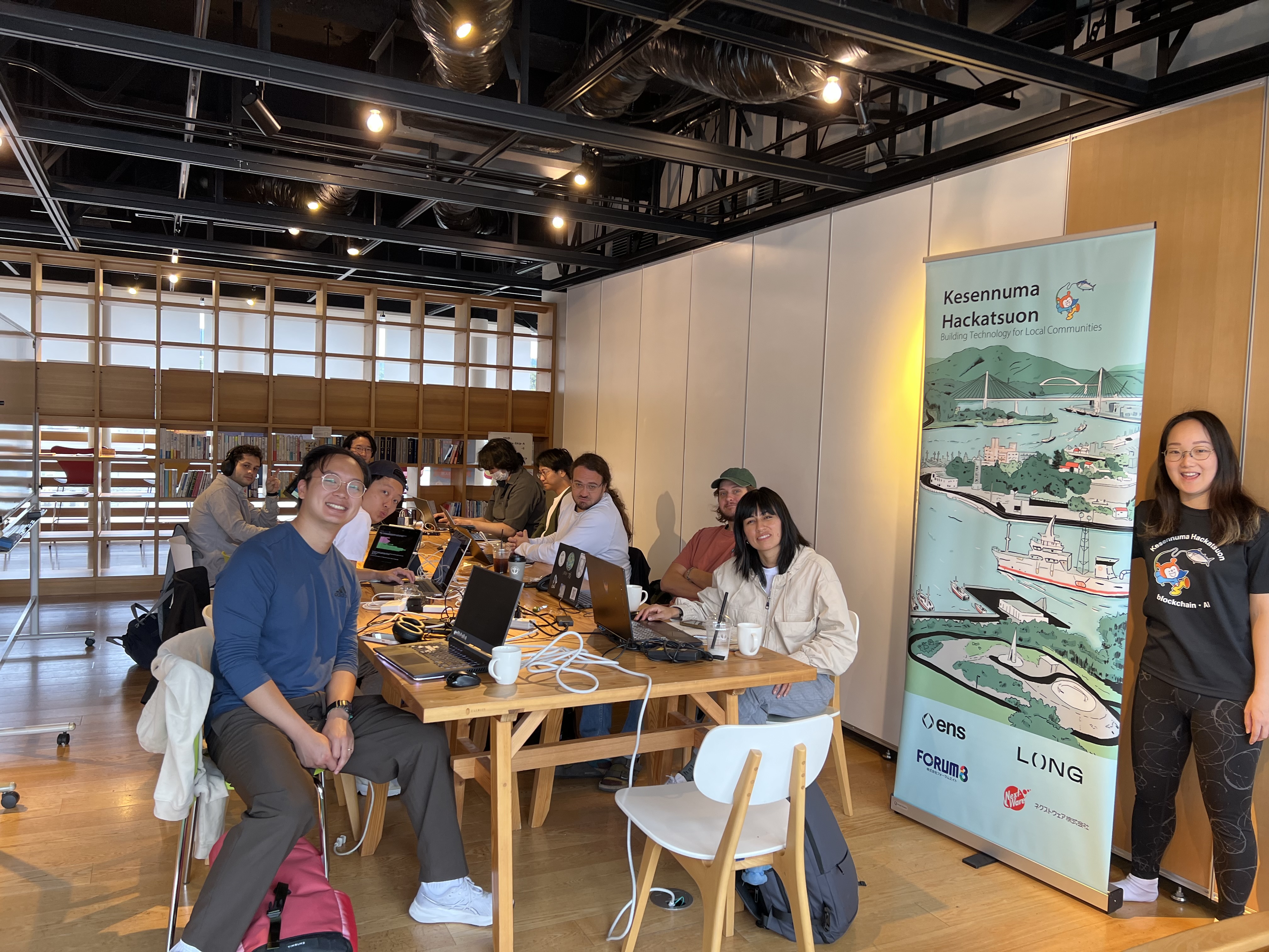 Development team working with Kesennuma Hackatsuon banner